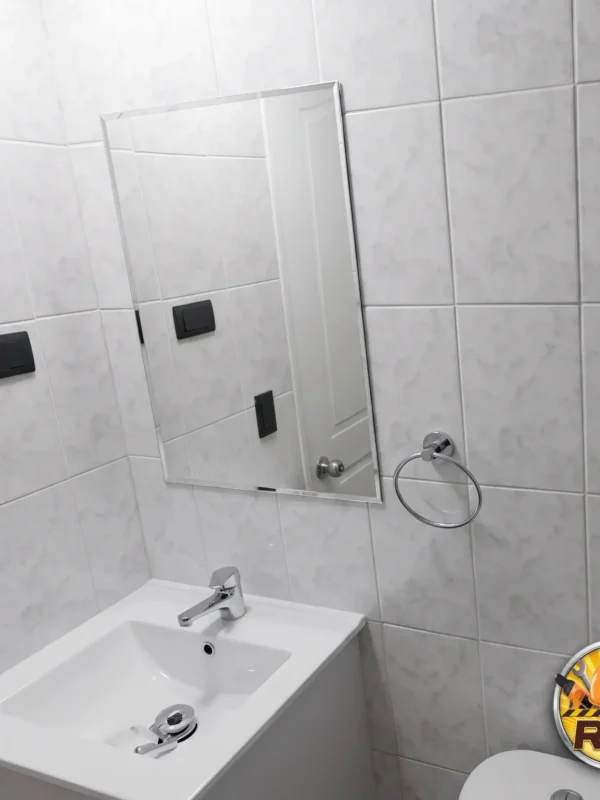 Baño renovado con cerámica de gran formato y ducha de vidrio